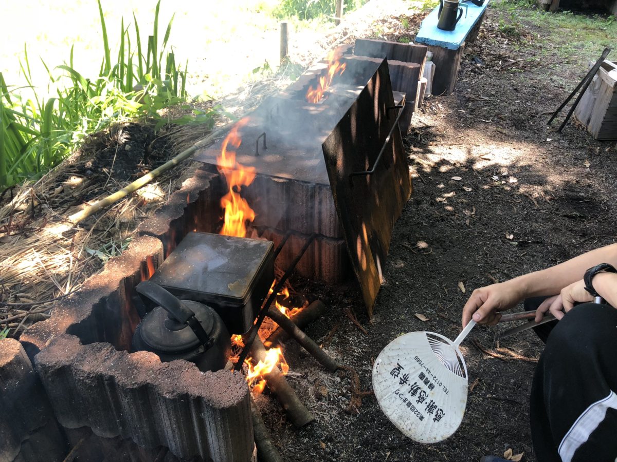 かまどで火を起こす様子