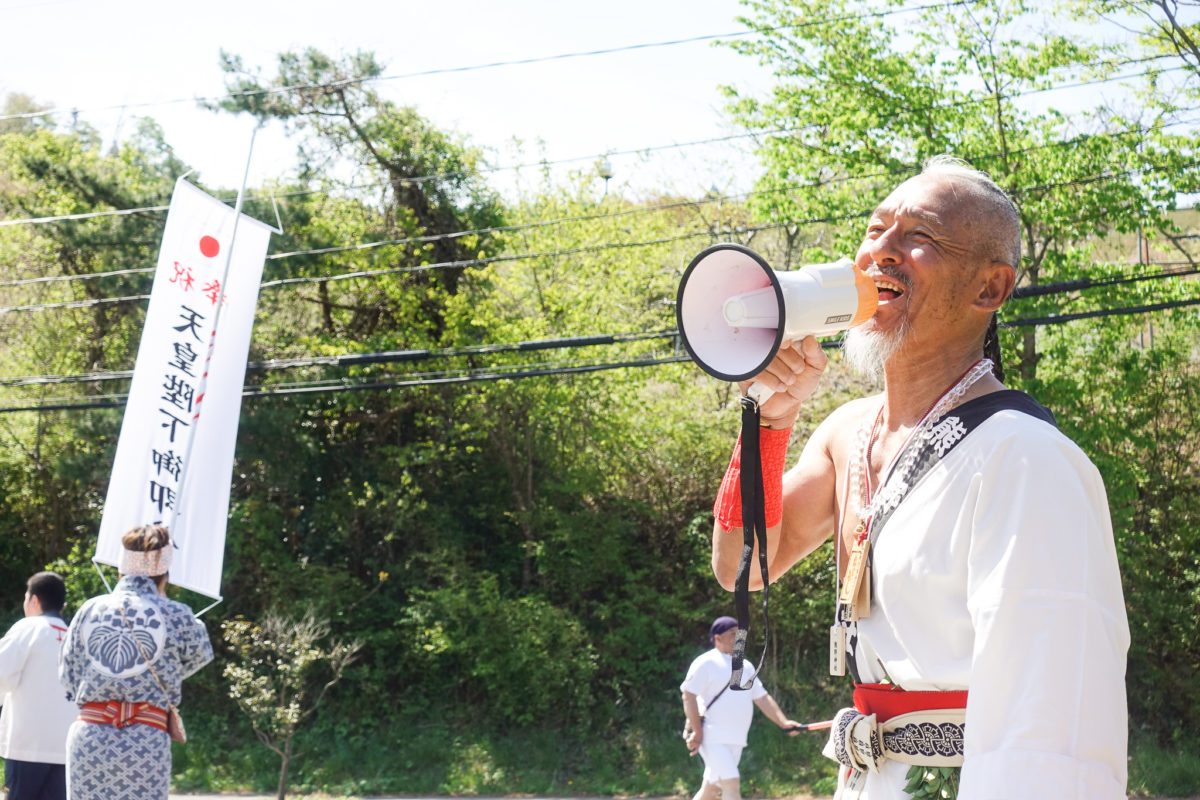 メガホンを取って行列へ檄を飛ばす岡さん