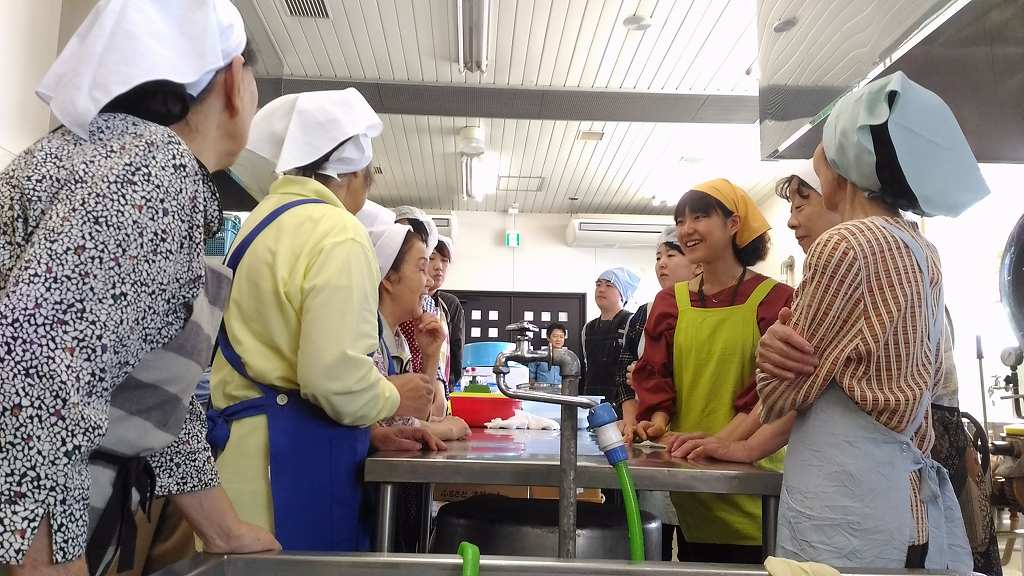 イベントで提供する、碇ヶ関名物のたけのこご飯づくり。あっという間に婦人会の皆さんと打ち解ける大学生たち