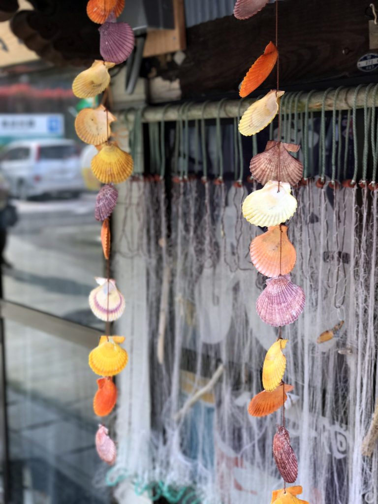 色鮮やかなヒオウギガイの貝殻が飾られた軒先