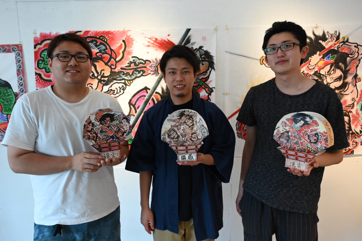 自分が担当したペーパークラフトを持つ3人