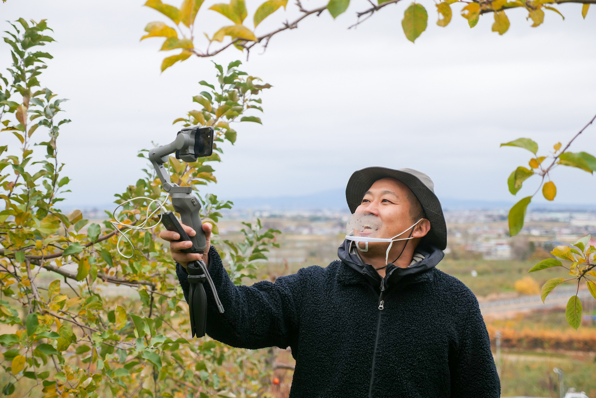 りんご園の様子を伝えるガイド役の畳指（たたみさし）さん